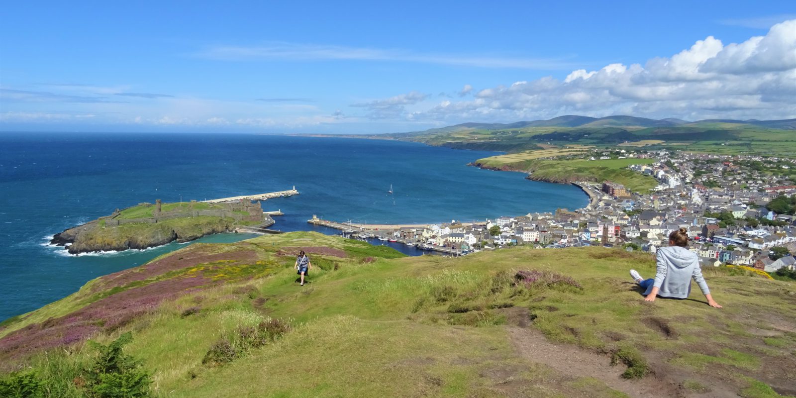 Someone sat down looking over Peel from Peel hill on a sunny day