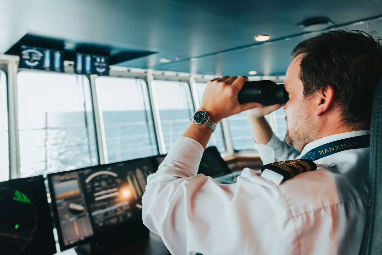 An officer of the watch keeps lookout from the bridge of Manxman during a crossing on a sunny day with calm seas