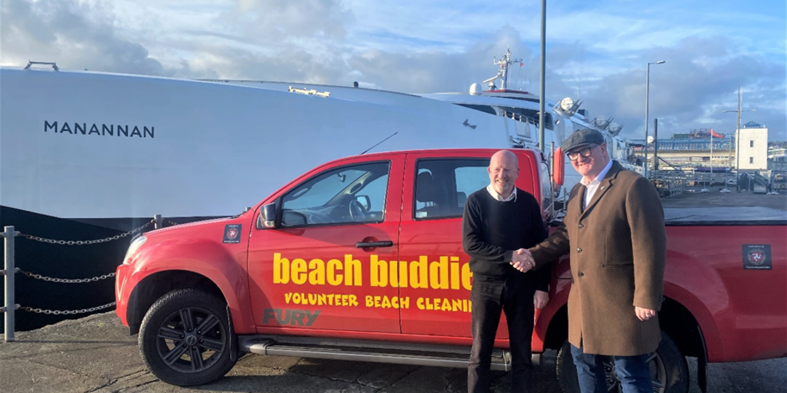 Two men shaking hands smiling in front of a 4x4 vehicle which is used for Beach Buddies Isle of Man beach cleaning