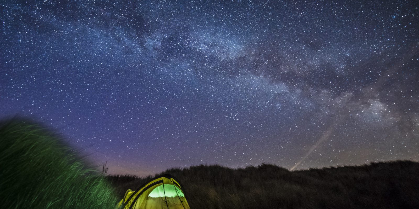 A star filled night sky at blue point beach, Isle of man.