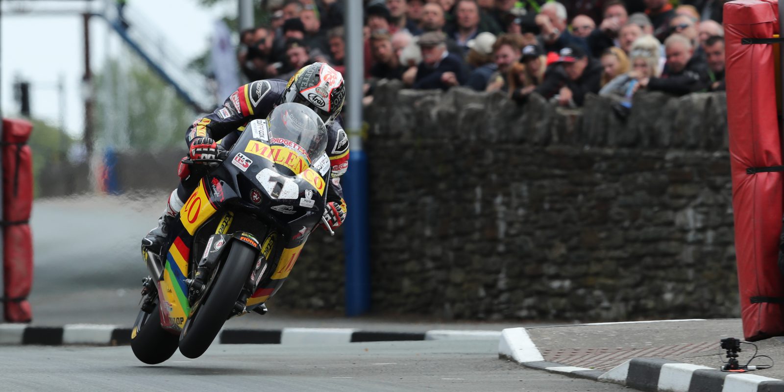 Conor Cummins on his motorbike with a crowd in the background