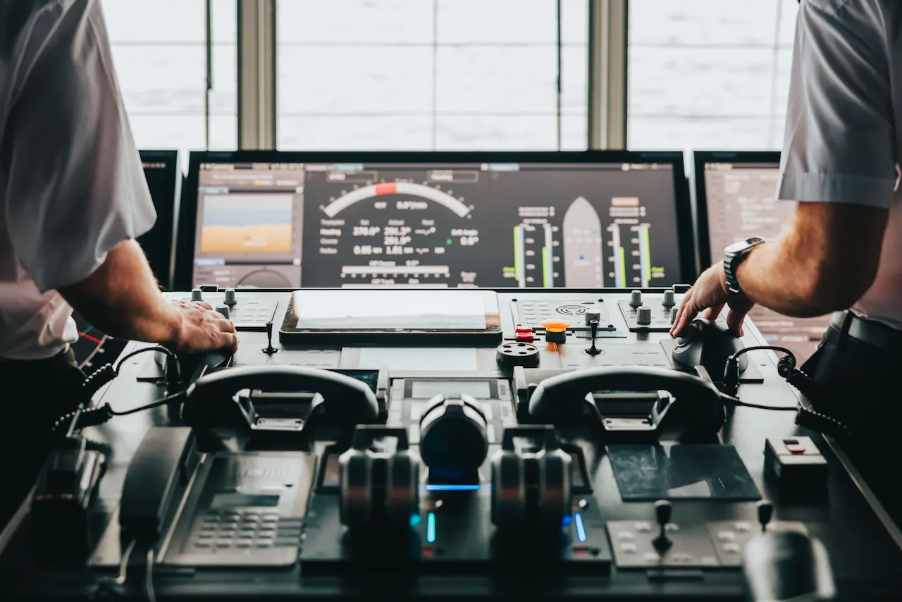 The master and first officers' hands on the helm controls of Manxman 